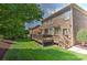 Manicured backyard with a deck, lush green lawn, and a brick house with a bay window at 3913 Widgeon Way, Waxhaw, NC 28173