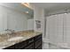 Bathroom with granite countertops, dark cabinets, a shower with white curtain, and modern fixtures at 3913 Widgeon Way, Waxhaw, NC 28173