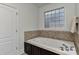 Bright bathroom with a soaking tub and a decorative window at 3913 Widgeon Way, Waxhaw, NC 28173