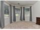 Bedroom featuring three windows and neutral carpeting and gray curtains at 3913 Widgeon Way, Waxhaw, NC 28173