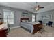 Bedroom with neutral tones, a ceiling fan, two windows, blue chairs and a wooden dresser at 3913 Widgeon Way, Waxhaw, NC 28173