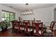 Dining room featuring a modern chandelier over a long dining table with ten upholstered chairs at 3913 Widgeon Way, Waxhaw, NC 28173