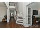 Elegant foyer with hardwood floors, staircase with wood banister and iron spindles, and open doorway at 3913 Widgeon Way, Waxhaw, NC 28173