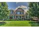 Brick two-story home with manicured lawn, lush trees and shrubbery under a blue sky with puffy white clouds at 3913 Widgeon Way, Waxhaw, NC 28173