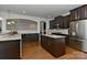 Open kitchen with dark cabinets, island, and stainless steel appliances at 3913 Widgeon Way, Waxhaw, NC 28173