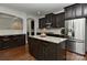 Well-equipped kitchen featuring dark cabinetry, stainless appliances and an island at 3913 Widgeon Way, Waxhaw, NC 28173