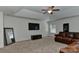 Living room featuring a ceiling fan, large windows, television, and a leather sofa at 3913 Widgeon Way, Waxhaw, NC 28173