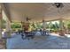Outdoor covered gathering area with stone fireplace, ceiling fans, and picnic tables at 3913 Widgeon Way, Waxhaw, NC 28173