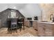 Basement bar with stools, sink, tile backsplash, cabinets and decorative brick wall at 4007 Lake Shore S Rd, Denver, NC 28037