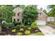 Brick home featuring a landscaped yard with mature trees and an attached garage at 4007 Lake Shore S Rd, Denver, NC 28037