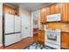 Traditional kitchen with warm wood cabinets, tile backsplash, modern appliances, and hardwood flooring at 4007 Lake Shore S Rd, Denver, NC 28037