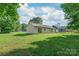 Large backyard with mature trees and a house with a sliding glass door at 425 Austin Dr, Charlotte, NC 28213