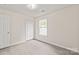 A bright bedroom with grey flooring, a window, and a closet at 425 Austin Dr, Charlotte, NC 28213