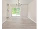 Open dining area with light gray floors, a chandelier, and sliding glass doors to the outside at 425 Austin Dr, Charlotte, NC 28213