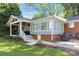 A well-maintained backyard boasts a covered patio, sunroom, brick accents, and tasteful landscaping at 4526 Longwood Dr, Charlotte, NC 28209