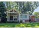 A charming home features a covered patio and a sunroom overlooking a lush, green backyard at 4526 Longwood Dr, Charlotte, NC 28209