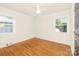 An empty bedroom shows hardwood floors, a ceiling fan, and two windows for natural light at 4526 Longwood Dr, Charlotte, NC 28209