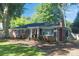 A single-story brick home with a well-manicured lawn and mature trees at 4526 Longwood Dr, Charlotte, NC 28209
