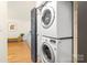 A closet with stackable washer and dryer with a door to access the rest of the home at 4526 Longwood Dr, Charlotte, NC 28209