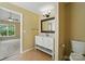 Bright bathroom with vanity, large mirror, and view into adjoining bedroom at 4982 Bentgrass Run Dr, Charlotte, NC 28269