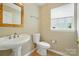 Charming half bathroom with pedestal sink, decorative mirror, and natural light at 4982 Bentgrass Run Dr, Charlotte, NC 28269