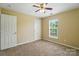 Neutral bedroom with ceiling fan, standard closet, and large window for ample lighting at 4982 Bentgrass Run Dr, Charlotte, NC 28269