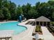 A large community pool with waterslide and cabana, surrounded by trees at 4982 Bentgrass Run Dr, Charlotte, NC 28269