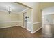 Open-concept layout with chandelier lighting, wood floors, and neutral paint at 4982 Bentgrass Run Dr, Charlotte, NC 28269