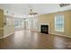 Spacious living room with a fireplace, ceiling fan, and natural light from large windows at 4982 Bentgrass Run Dr, Charlotte, NC 28269