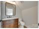 Modern bathroom with stained vanity, marble countertop, and a square mirror at 513 Sacco St, Belmont, NC 28012