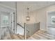 Hallway view with a staircase featuring an ornate light fixture and luxury vinyl plank flooring at 513 Sacco St, Belmont, NC 28012
