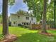 Spacious backyard featuring a brick patio, lush lawn, and mature trees for a private outdoor space at 5436 Topping Pl, Charlotte, NC 28209