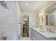 Bathroom featuring double sinks, modern fixtures, marble floors, and a glass-enclosed shower at 5436 Topping Pl, Charlotte, NC 28209