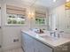 The bathroom features a double sink vanity with a large mirror, windows, and updated fixtures at 5436 Topping Pl, Charlotte, NC 28209