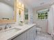 Bathroom featuring double sinks, modern fixtures, marble floors, and a window providing natural light at 5436 Topping Pl, Charlotte, NC 28209
