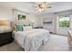 Bright bedroom with a ceiling fan, large windows, and decorative pillows and artwork at 5436 Topping Pl, Charlotte, NC 28209
