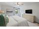 This light bedroom features a large bed, ceiling fan, windows, and dresser with a television at 5436 Topping Pl, Charlotte, NC 28209