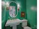 This powder room features green walls, sconces, a decorative mirror, and pedestal sink at 5436 Topping Pl, Charlotte, NC 28209