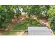 A serene backyard with a stone pathway, a firepit with Adirondack chairs, and mature trees by the lake at 6836 Summer Hill Dr, Denver, NC 28037