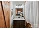 Bathroom featuring wood walls, sink, vanity and framed mirror at 6836 Summer Hill Dr, Denver, NC 28037
