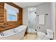 Bathroom featuring wood walls, walk-in shower, tub and picture window at 6836 Summer Hill Dr, Denver, NC 28037