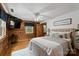 Bedroom features wooden walls, wood floors, and a bed with a white and gray cover at 6836 Summer Hill Dr, Denver, NC 28037