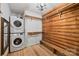 Washer and dryer in wood walled closet with shelving and bench at 6836 Summer Hill Dr, Denver, NC 28037