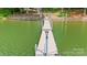 Scenic view of a private wooden dock leading out into the calm water, offering serene lakeside access at 6836 Summer Hill Dr, Denver, NC 28037