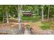 Charming log cabin nestled amongst mature trees features a backyard fire pit with dock access on the lake at 6836 Summer Hill Dr, Denver, NC 28037