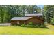 Exterior of a log cabin home with a lush lawn, mature landscaping, and a private, wooded setting at 6836 Summer Hill Dr, Denver, NC 28037