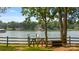 Picturesque lake view with a wooden fence and gate, inviting you to explore the serene waterfront property at 6836 Summer Hill Dr, Denver, NC 28037