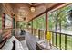 Inviting covered porch with comfortable seating, offering stunning views of the lake and surrounding woods at 6836 Summer Hill Dr, Denver, NC 28037
