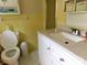 Bright yellow bathroom with a white vanity, toilet, and tiled walls showcasing a clean and classic design at 714 Shady Dr, Albemarle, NC 28001