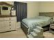 Comfortable bedroom featuring a bed with pet stairs, a dresser, and curtains creating a relaxing atmosphere at 714 Shady Dr, Albemarle, NC 28001